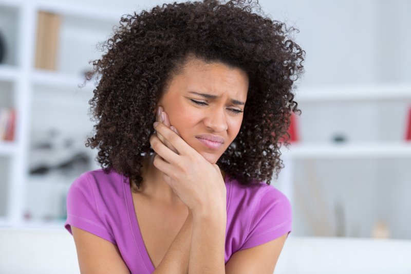 Patient holding cheek due to a minor dental emergency